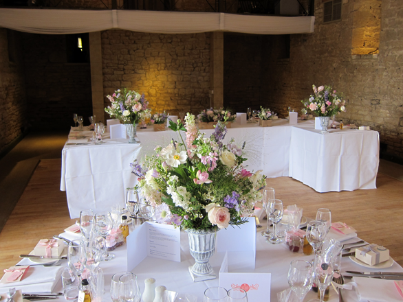A natural cottage garden urn display in pastel shades at the Great Tythe Barn, Tetbury. Floral design by Cotswold Blooms, wedding florist based in Cheltenham.