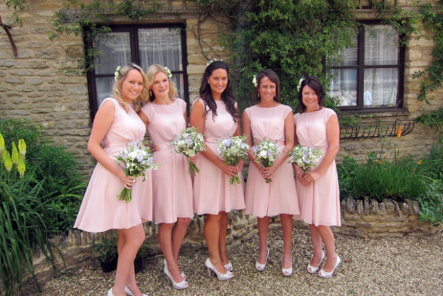 Bridesmaids with bouquets and hair flowers at The Great Tythe Barn, Tetbury.Floral design by Cotswold Blooms, wedding florist based in Cheltenham.