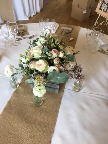 Crate table display filled with Roses and Waxflower, set on a hessian runner. Floral design by Cotswold Blooms, wedding florist based in Cheltenham.