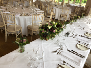 Burgundy and dusky pink flowers in glass jars and rustic boxes. Floral design by Cotswold Blooms, wedding florist based in Cheltenham.