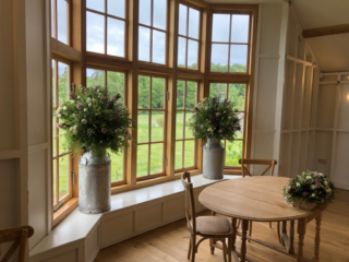 Milk churns and a rustic box display at the Grange, Hyde House. Floral design by Cotswold Blooms, wedding florist based in Cheltenham.
