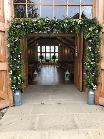 Floral arch and ceremony setup at the Grange, Hyde House. Floral design by Cotswold Blooms, wedding florist based in Cheltenham.