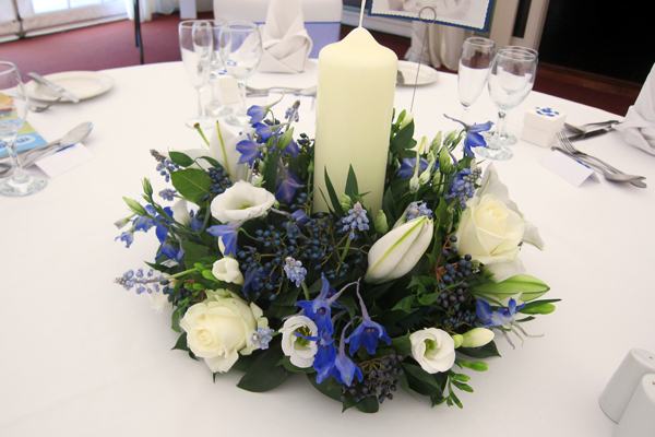 Blue Delphinium and Viburnum Berry with Lily and Roses for a traditional table centre. Floral design by Cotswold Blooms, wedding florist based in Cheltenham.