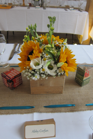 Sunflowers, Tacanatium and Stocks in a wooden box. Floral design by Cotswold Blooms, wedding florist based in Cheltenham.