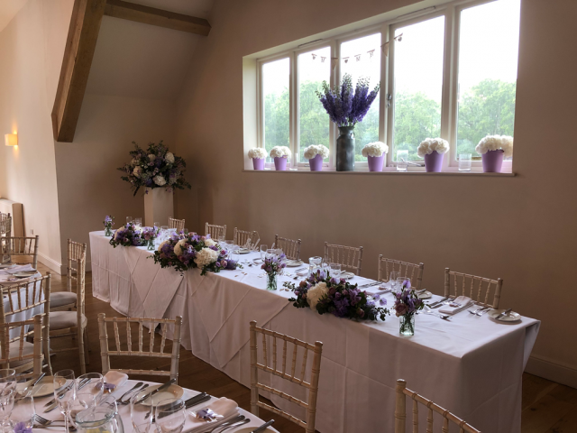 Delphinium and Hydrangea dressing top table and the window at Hyde House, Stow-on-the-Wold.  Floral design by Cotswold Blooms, wedding florist based in Cheltenham.