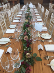 A mixed foliage table runner with Pepperberry and Roses at Elmore Court. Floral design by Cotswold Blooms, wedding florist based in Cheltenham.