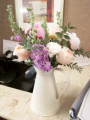 Soft pastel flowers in a enamel jug at the Rembrandt Hotel, London. Floral design by Cotswold Blooms, wedding florist based in Cheltenham.