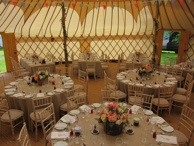 Yurt filled with country garden displays in birch bowls, with coral Peonies and blue Nigella. Floral design by Cotswold Blooms, wedding florist based in Cheltenham.