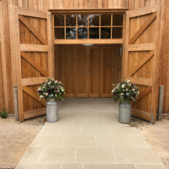 Milk churns of Safari, Astilbe, Roses and Heather at the Grange, Hyde House. Floral design by Cotswold Blooms, wedding florist based in Cheltenham.