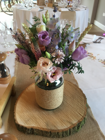 Country garden Jar display in soft pinks, blue, purple and dried crops. Floral design by Cotswold Blooms, wedding florist based in Cheltenham.