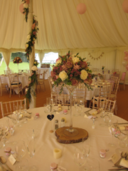 Martini vase display with pillar garlands in a marquee. Floral design by Cotswold Blooms, wedding florist based in Cheltenham.