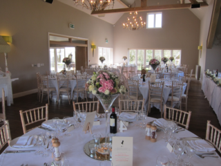 Martini vases on mirror bases surrounded with candles. Floral design by Cotswold Blooms, wedding florist based in Cheltenham.