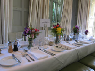 Bright vibrant jars filled with country garden flowers at Barnsley House Hotel. Floral design by Cotswold Blooms, wedding florist based in Cheltenham.