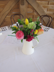 Spring flowers in bright pastel tones including Tulips, Ranunculus, Stocks and Viburnum at Cripps Barn. Floral design by Cotswold Blooms, wedding florist based in Cheltenham.