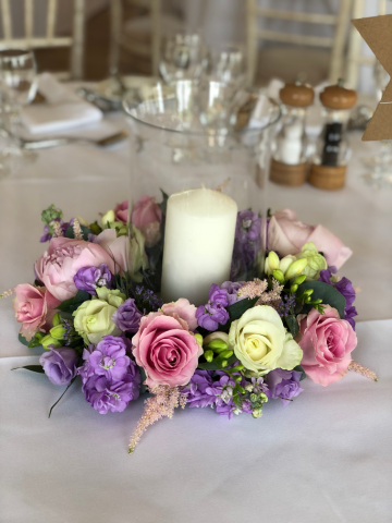 Lilac, light pink and white Roses, Stocks and Astilbe with a hurricane vase.  Floral design by Cotswold Blooms, wedding florist based in Cheltenham.