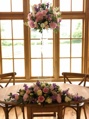 Glass urn display or Hydrangeas, Stocks and Peonies with a long and low matching registrars table display. Floral design by Cotswold Blooms, wedding florist based in Cheltenham.