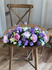 Long and low displays in lilac, light pink and white Peonies, Roses, Eustoma and Astilbe. Floral design by Cotswold Blooms, wedding florist based in Cheltenham.