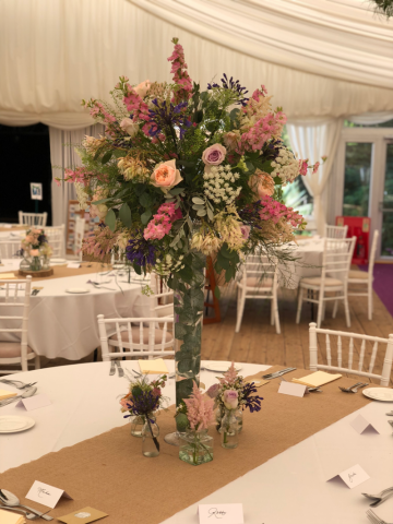 Lily vase display with a full display of Eucalyptus, Agapanthus, Roses, Delphinium and Astilbe at Hockwold Hall. Floral design by Cotswold Blooms, wedding florist based in Cheltenham.