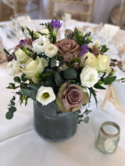 Mini milk churn display filled with dusky pink, purple and white. Floral design by Cotswold Blooms, wedding florist based in Cheltenham.