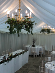 Dressed chandelier lights and tables at Birtsmorton Court. Floral design by Cotswold Blooms, wedding florist based in Cheltenham.