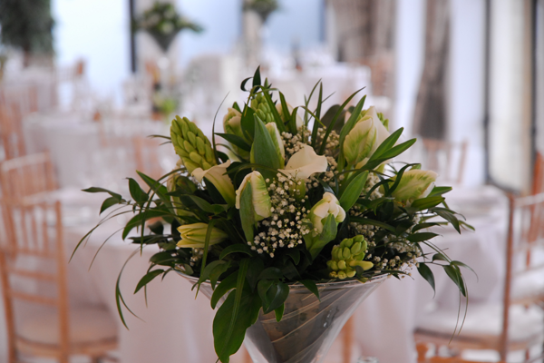 Fresh and bright Martini vase table centre. Floral design by Cotswold Blooms, wedding florist based in Cheltenham.