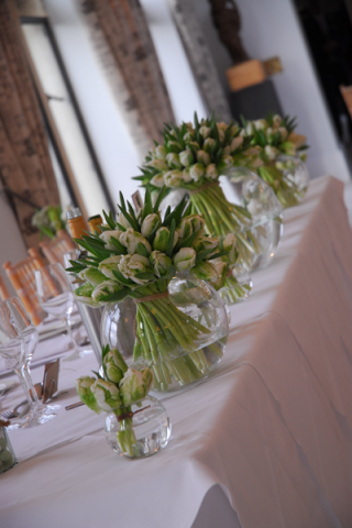Parrot Tulip fish bowls on the top table. Floral design by Cotswold Blooms, wedding florist based in Cheltenham.