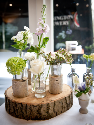 Specimen display in a natural style on wood slice and in mini buckets. Floral design by Cotswold Blooms, wedding florist based in Cheltenham.