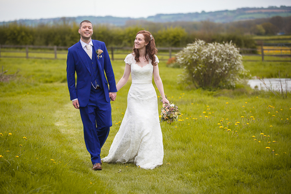 Happy bride and groom on their wedding day. Photo by Louise Bowles Photography. Floral design by Cotswold Blooms, wedding florist based in Cheltenham.