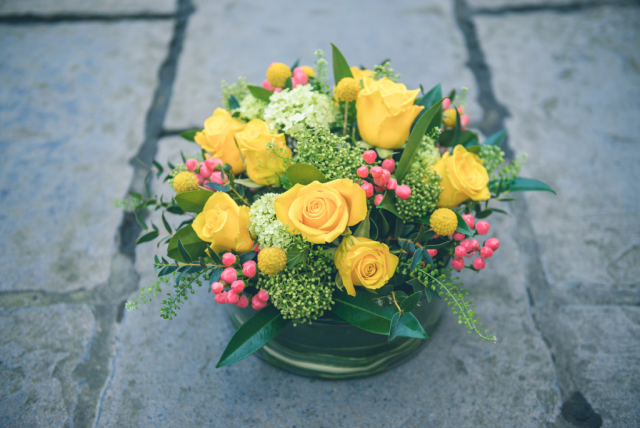 Yellow and lime green table display, including Crispedia and Roses. Floral design by Cotswold Blooms, wedding florist based in Cheltenham.