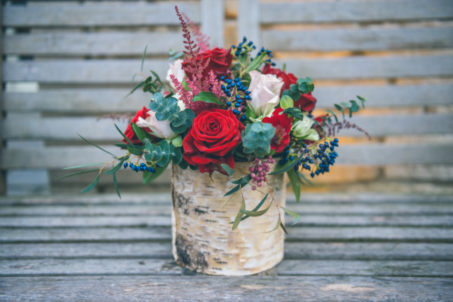 Birch bowl with rich red Roses and vibrant Viburnum berries. Floral design by Cotswold Blooms, wedding florist based in Cheltenham.