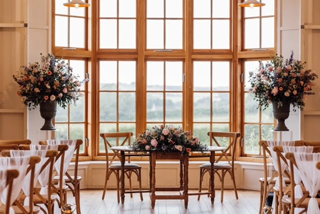 Boho-style urn floral displays for a wedding ceremony at The Grange, Hyde House, Stow-on-the-Wold