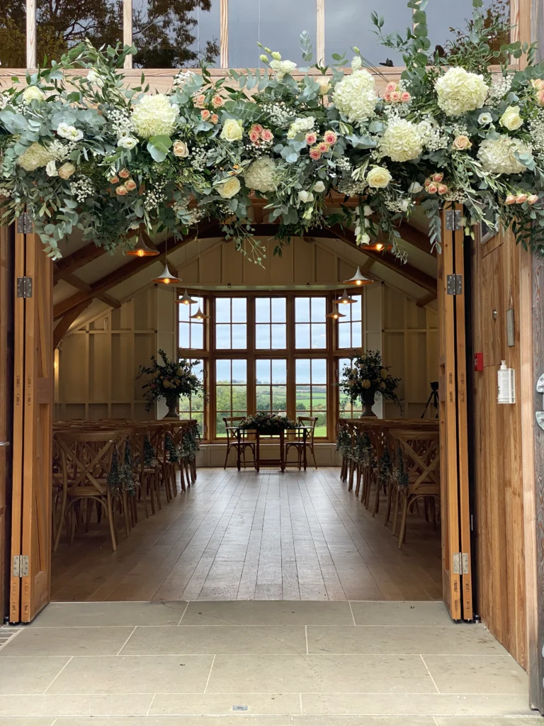 Floral arch-style entrance display with hydrangea, rose and eucalyptus at The Grange, Hyde House