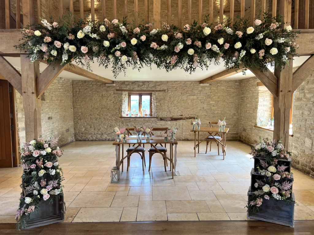 Kingscote Barn wedding flowers featuring crate arrangements and balcony florals