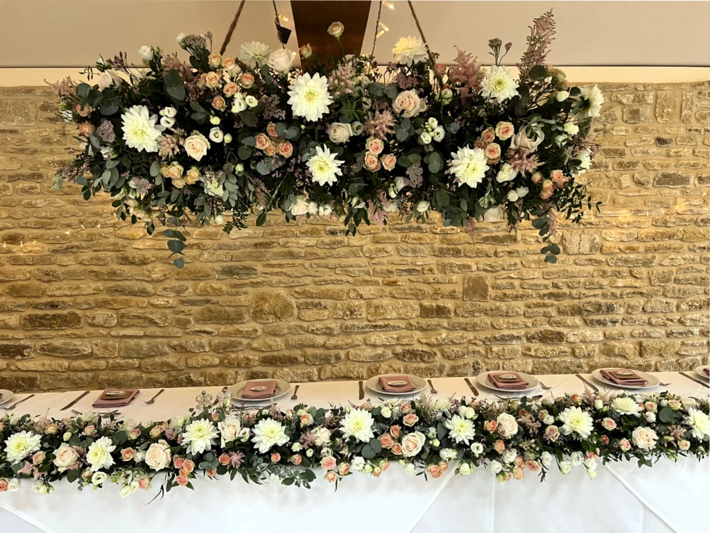 Wedding hanging floral firework feature with coordinated table runner arrangement