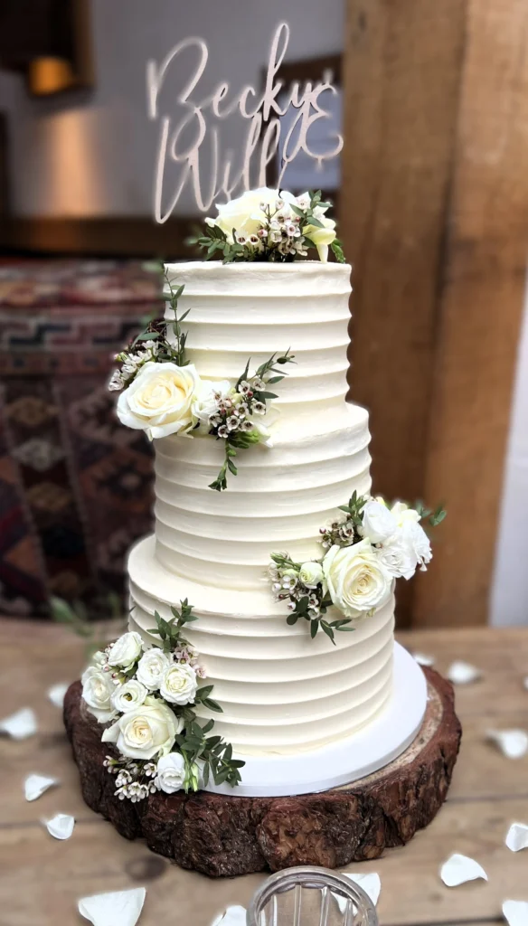 Cake decorated with roses, waxflower and eustoma