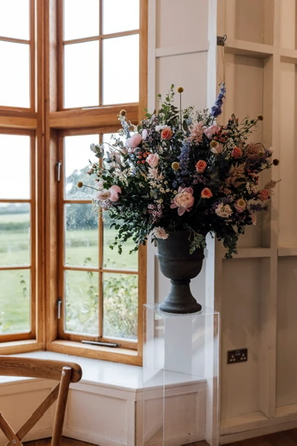 Bohemian-style urn arrangement featuring blue and coral tones