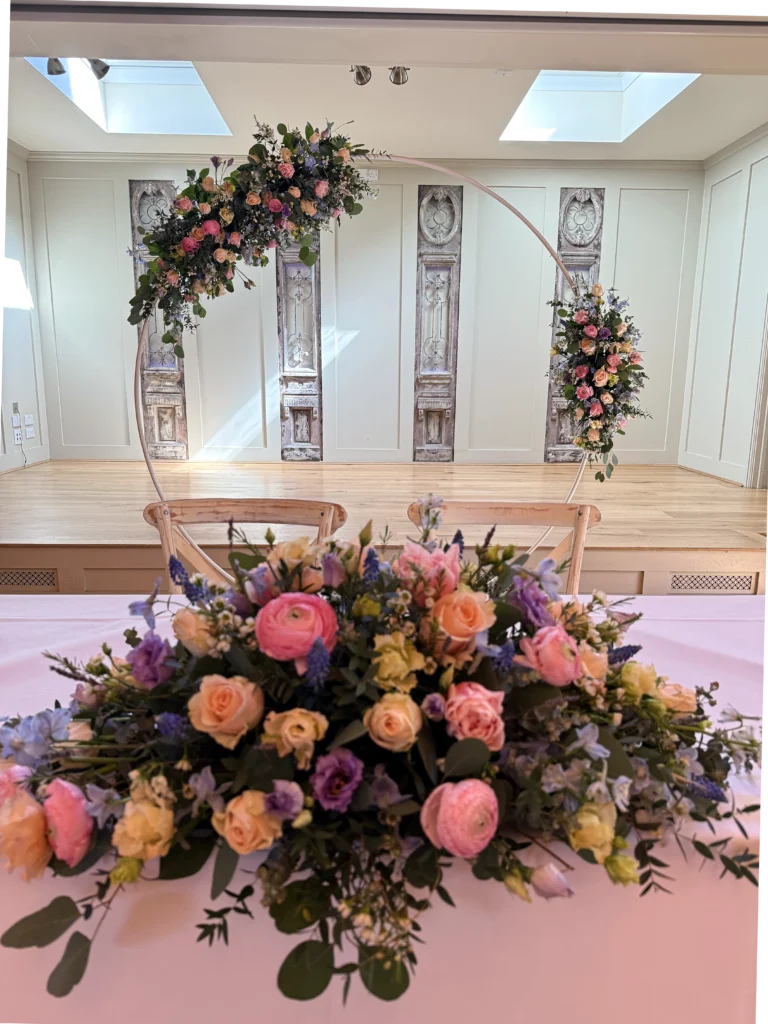 Wedding moon gate installation with roses and ranunculus at The Frogmill