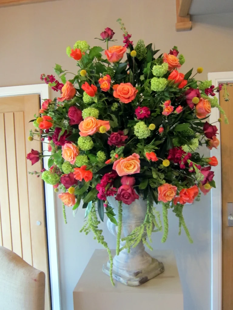 Stone urn entrance arrangement in bright and vibrant colours at Hyde House