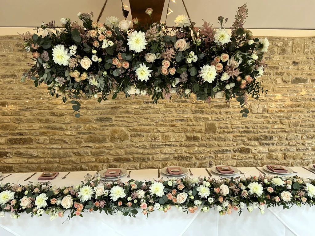 Hanging floral firework display above the top table with matching table centre runne