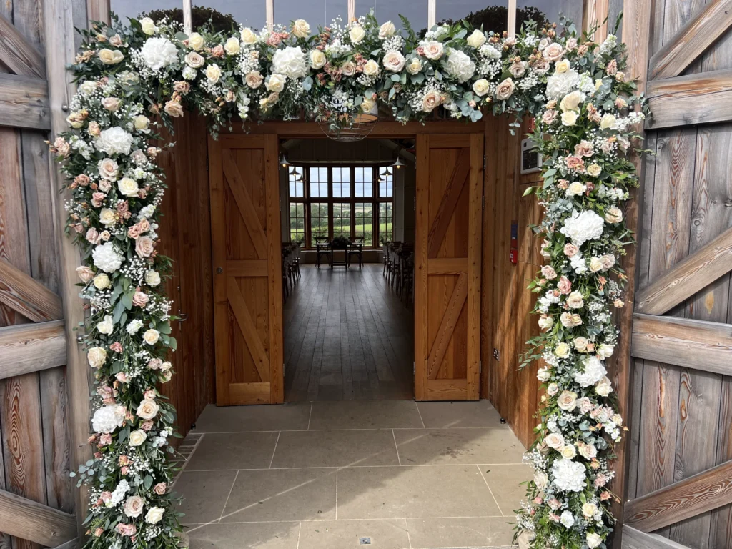 Ceremony entrance styling with nude and white natural flowers at The Grange, Hyde House