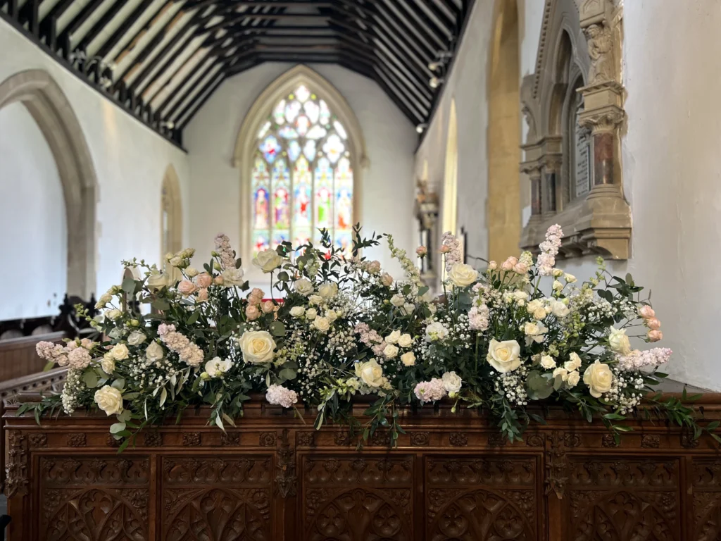 Country garden-inspired floral styling at the front of the church