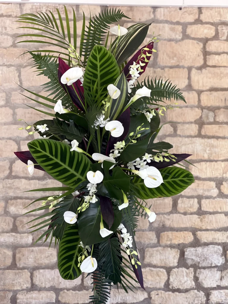 Modern floral display with tropical foliage, calla lilies and anthurium