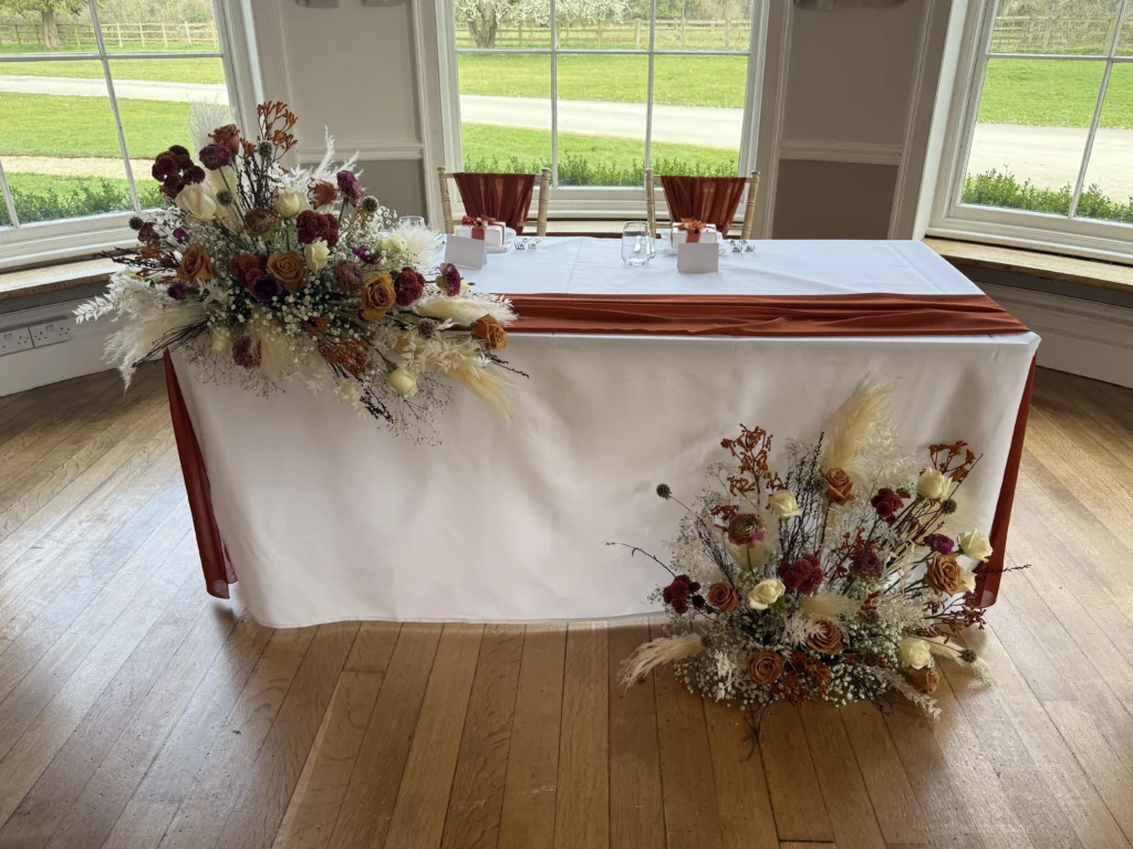 Elegant sweetheart table with asymmetrical florals in cappuccino and cream tones
