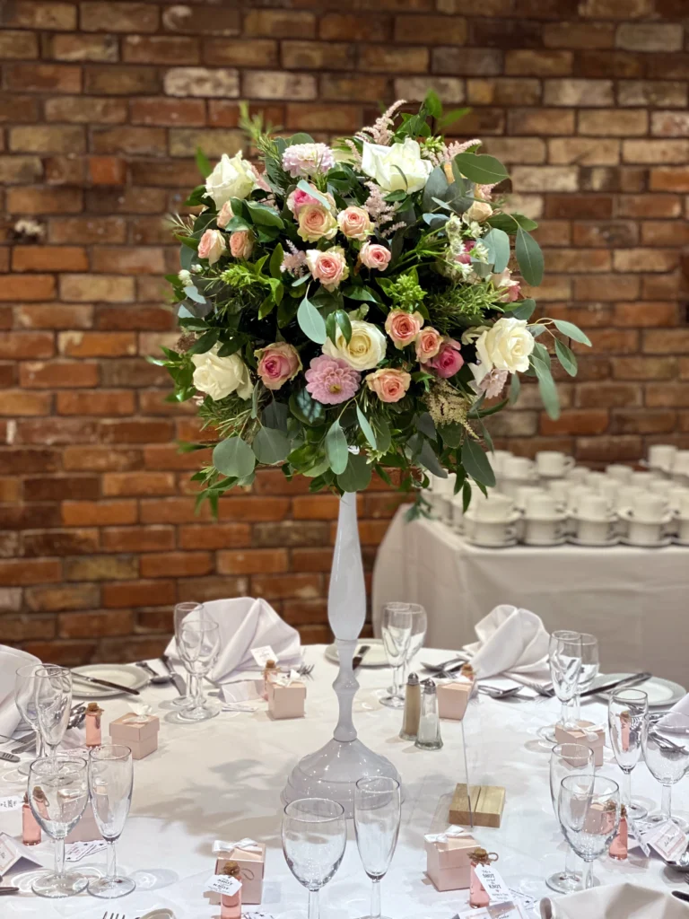 Romantic flower bowl elevated on a white stand at Hatherley Manor