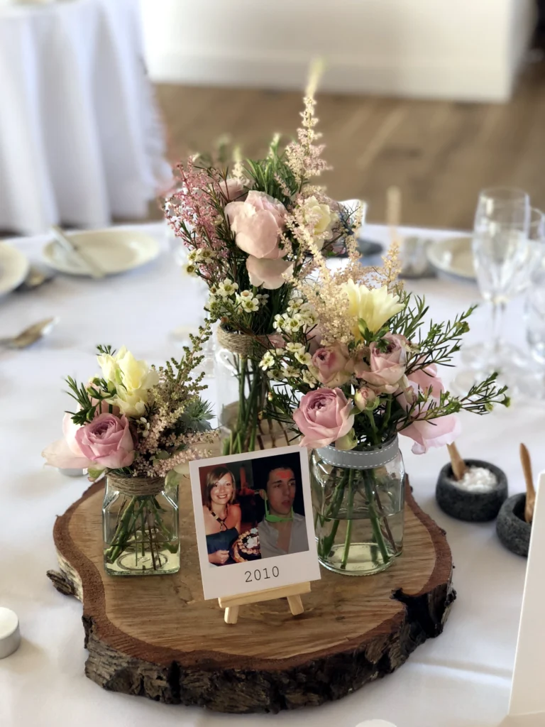 Hyde House table styling with wildflower jars on a wooden slice