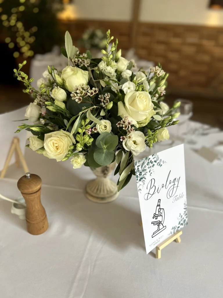 Cripps Stone Barn rustic urn table arrangement with roses and delphinium
