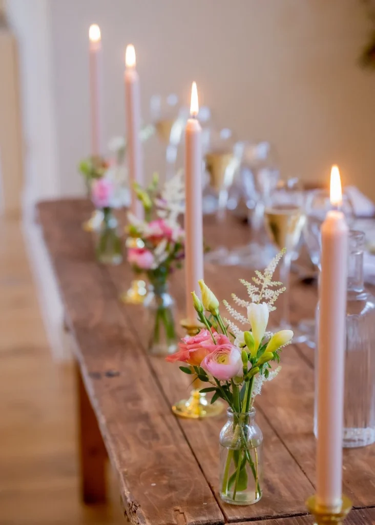 Elegant bud vases along top table in dusky pink tones