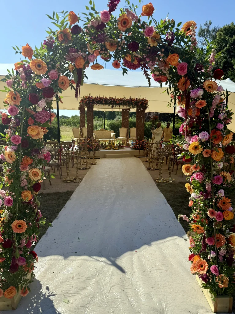 Bold and vibrant boho arch installation for a Hindu ceremony at The Matara Centre, Tetbury