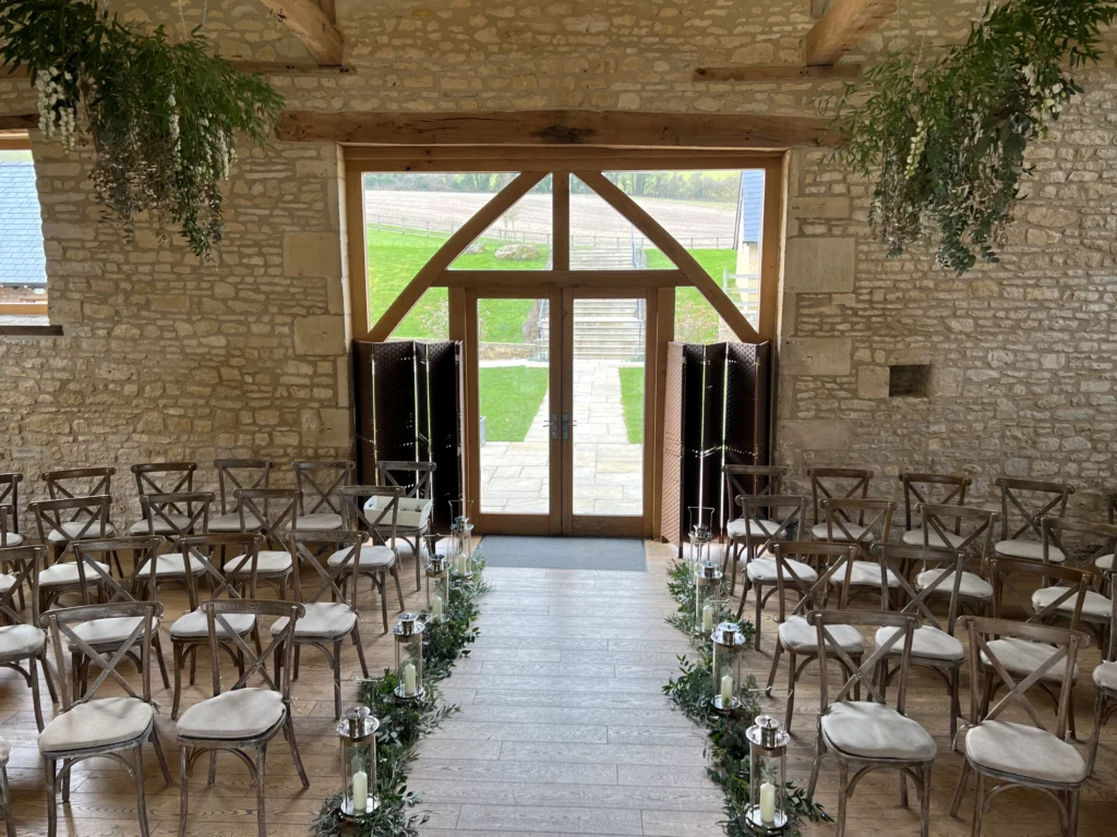 Delphinium and foliage aisle design with hanging greenery at Barn at Upcote