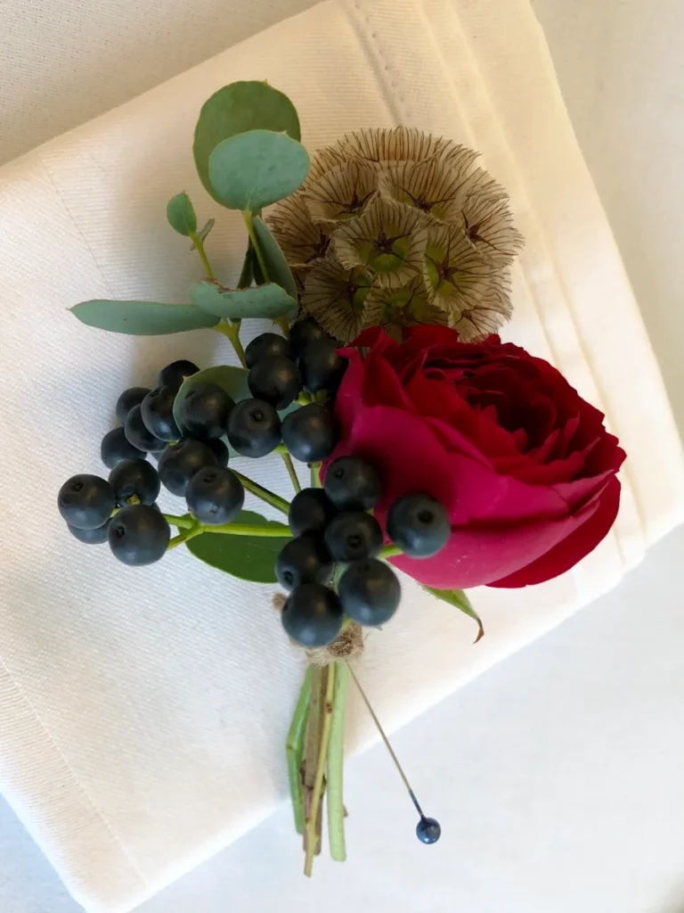 Textured buttonhole with scabiosa seed pod, rose and berry accents